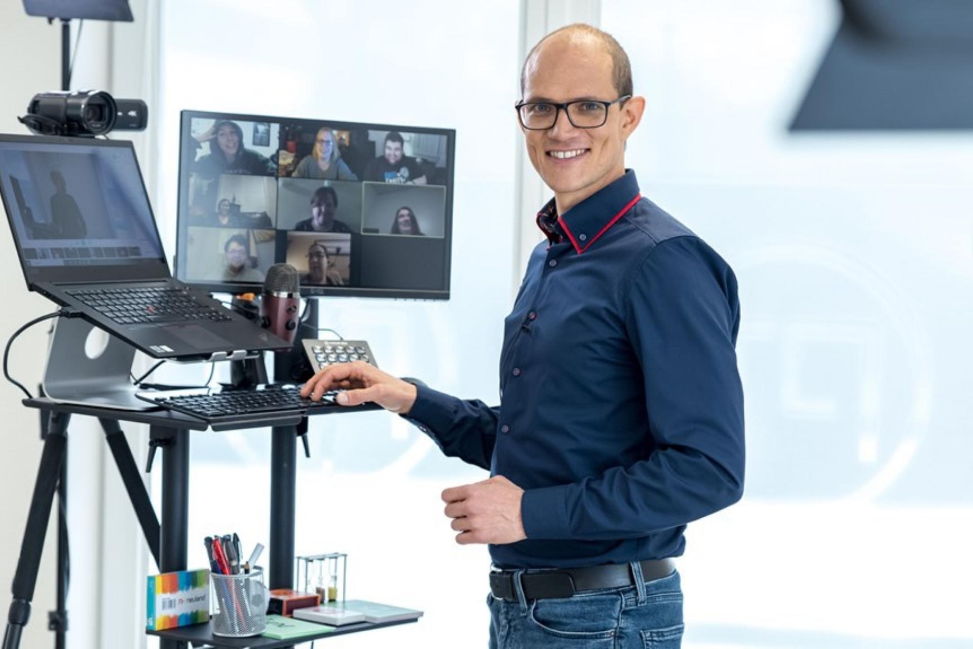 Steffen Moll in einem Online Präsentationstraining vor Laptop und Bildschirm mit Videokonferenz